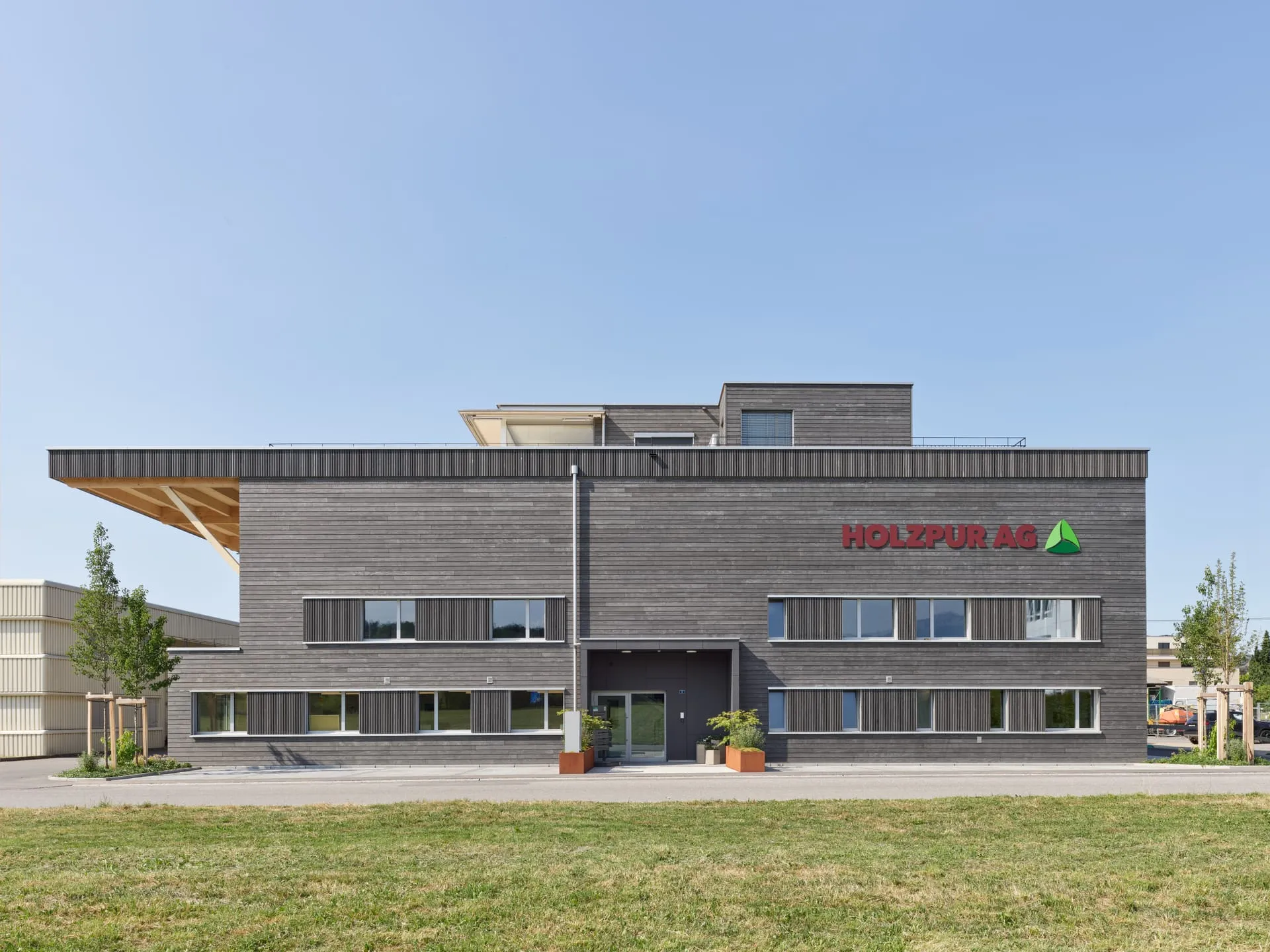 Holzpur AG Sempach Station — Frontansicht mit Holzfassade